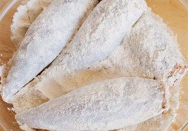 Trộn bột mì với muối và hạt tiêu, sau đó lăn cá qua bột mì.